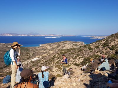 People sit on a rocky cliffside overlooking the ocean