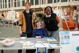 Three students posing by their research
