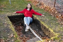 Student sitting in excavation hole