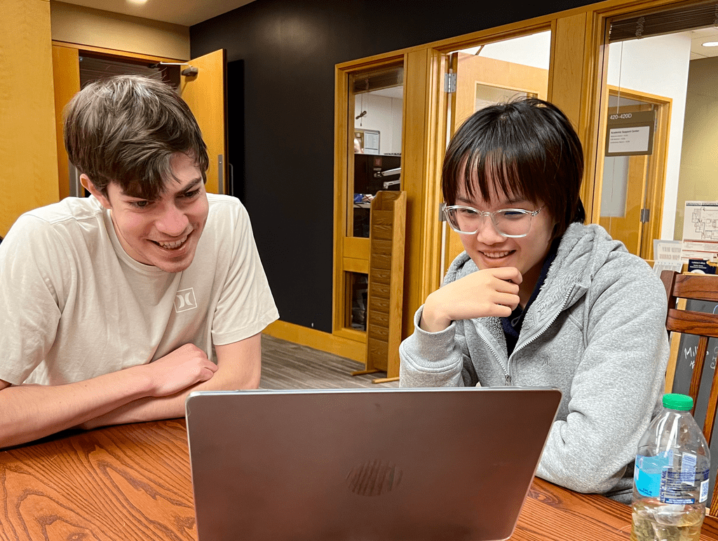 Students sit side by side during a writing consultation