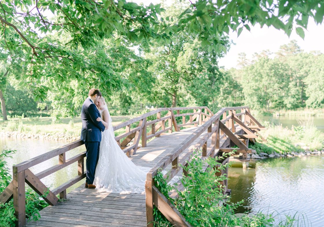 bride and groom embrace on a bridge