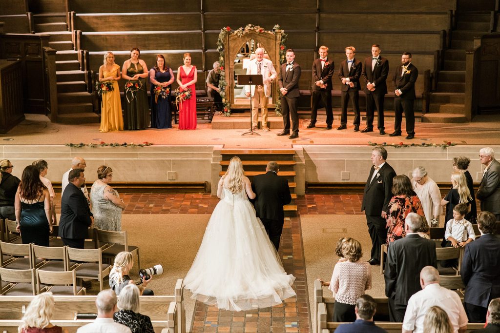 bride walks down the aisle at wedding ceremony