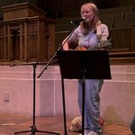 Carleton singing with guitar at National Coming Out Day Service
