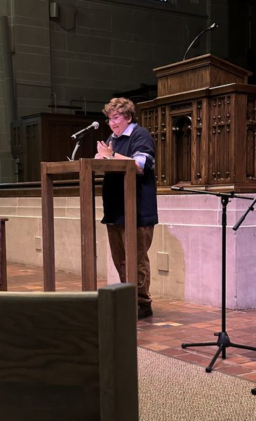 Student giving a talk at a podium at National Coming Out Day Service