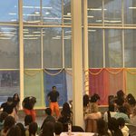 Students seated at tables watching a group of student dancers perform