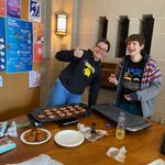 Two students laughing while cooking latkes
