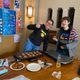 Two students laughing while cooking latkes