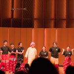 Lion dancers on stage with the lion costumes removed