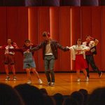 Five students on stage dancing
