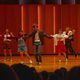 Five students on stage dancing
