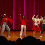 Three students on stage dancing