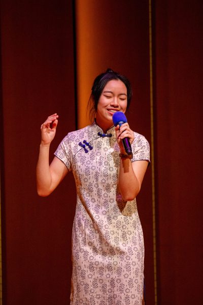 One student on stage with a mic performing a song