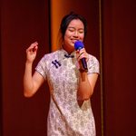 One student on stage with a mic performing a song