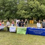 Students and staff at a NSW tabling event on the bald spot. 4 tables with signs that include the Office of the Chaplain, Carleton Druids and Episcopal Student Association