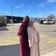 Two students posing back to back for picture on Eid