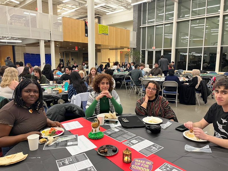 Group of students sitting at a table at the Knightly Iftar