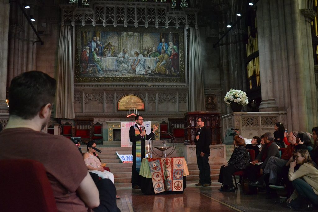 Rev. Schuyler Vogel, College Chaplain, in the front of the Unitarian Universalist sanctuary in New York. Behind him is the mosaic of Jesus washing the disciples feet.