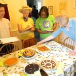 The judges (Bia, Jean and Carolyn) carefully evaluate each pie under Julia's careful supervision.