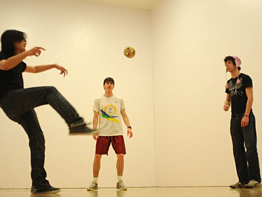 Three students playing with a ball