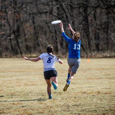 a player jumps in the air to catch a Frisbee