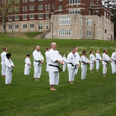 Karatekas practicing kata on Bell Field under the instruction of Kyoshi Mackay