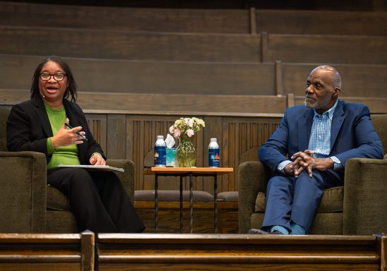 Dean Carolyn Livingston & Justice Alan Page having a conversation on Chapel stage.