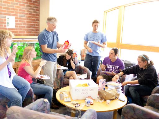 Students and professor sharing snacks around a circular table