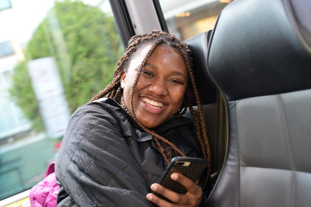 A student on a bus holding a mobile phone