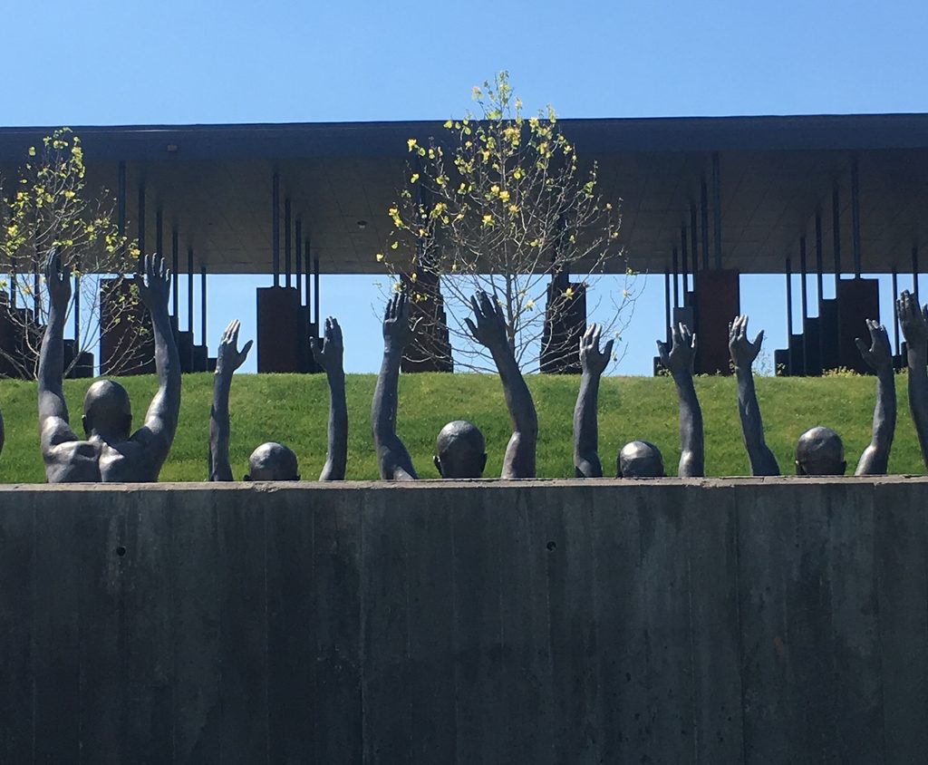 A sculpture of men with their hands raised