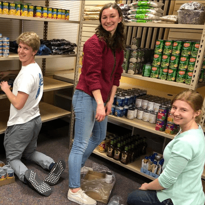 FRN program directors helping stock the shelves at the temporary food shelf location.