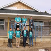 ASB group poses in front of Habitat home.