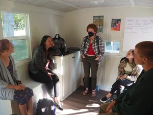 4 people sit in a circle inside the trailer