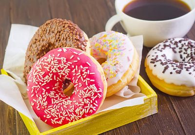 Colorful frosted donuts a black coffee