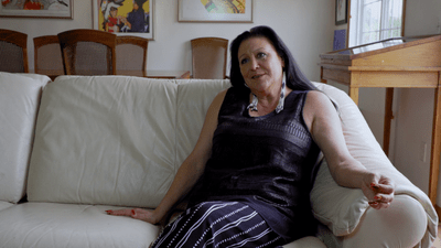 Ramona Kitto Stately seated on a white couch in her living room