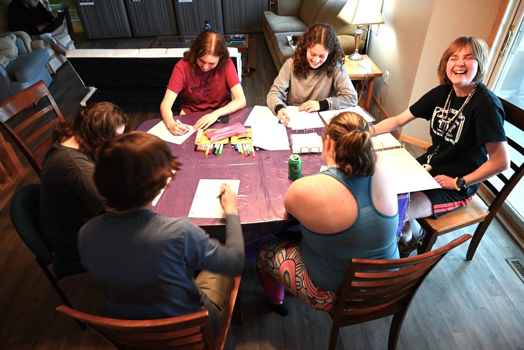 Students sitting around a table writing