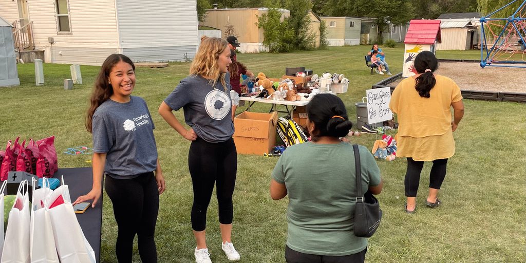 Summer interns helping staff a yard sale fundraiser