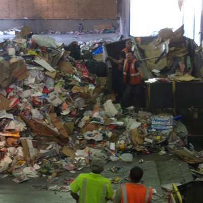 A load of commingled recyclables before it has been pushed onto a conveyor belt and hand sorted.