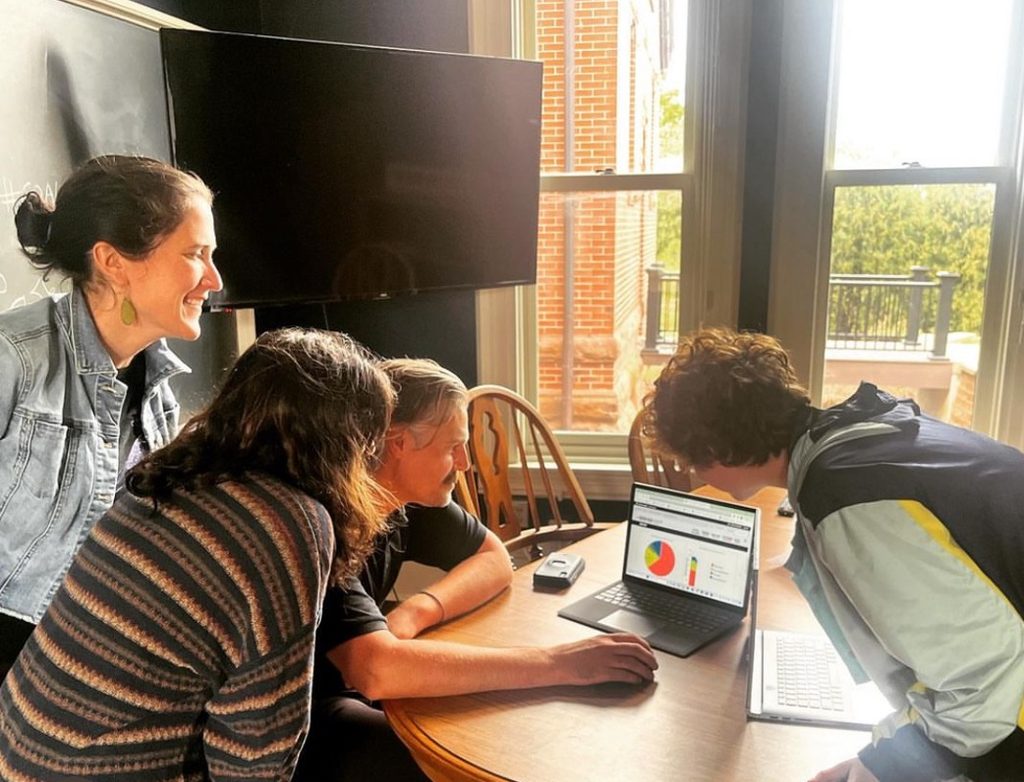 people gathered around computer showing a graph