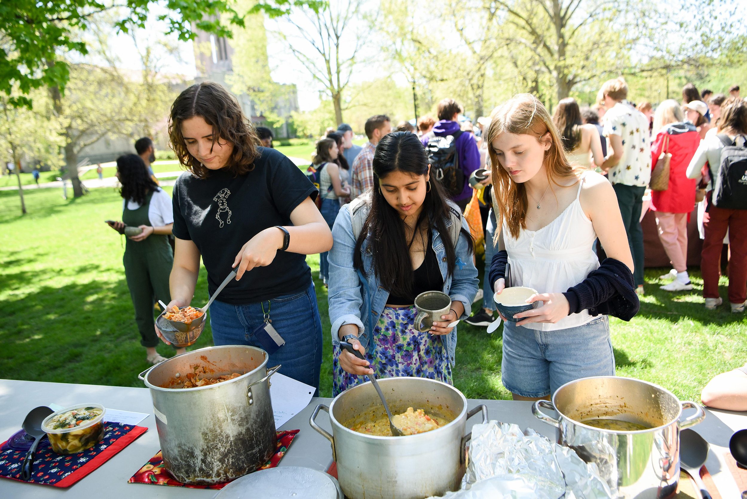 Students pour soup into handmade bowls on the college Bald Spot