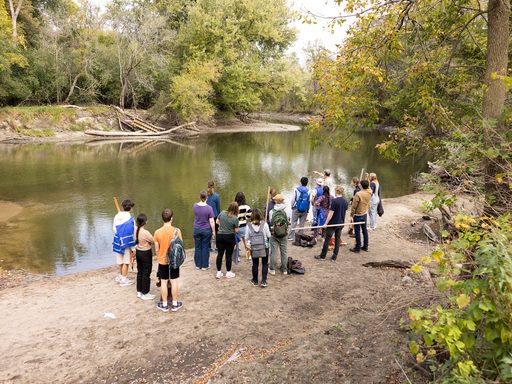 Geology class stands next to a river