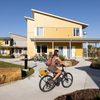 Student biking in front of passive solar, sustainable student housing buildings on Carleton College's campus