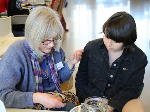 A community member helps a student repair an item at the Repair Fair