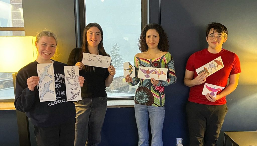 4 students posing with bird decals