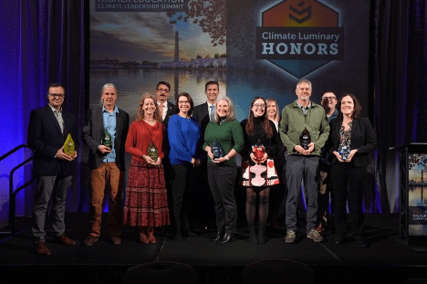 award winners pose on stage for group photo