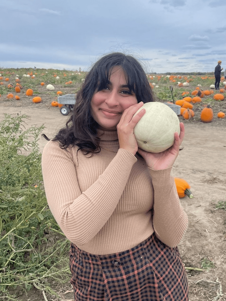 juliana holding a pumpkin in a pumpkin patch