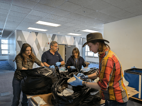 group of four people sorting trash