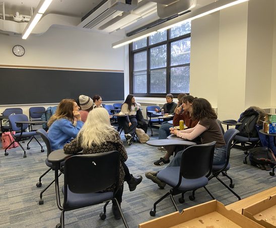 A group of GWSS students enjoying pizza in a Leighton classroom at the winter '24 Pizza Party.
