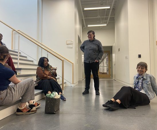 GWSS faculty members sitting in the Weitz basement at the spring '24 Strawberries & Chocolate Celebration.