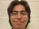 Ivan Delgado smiling at the camera against a white background.