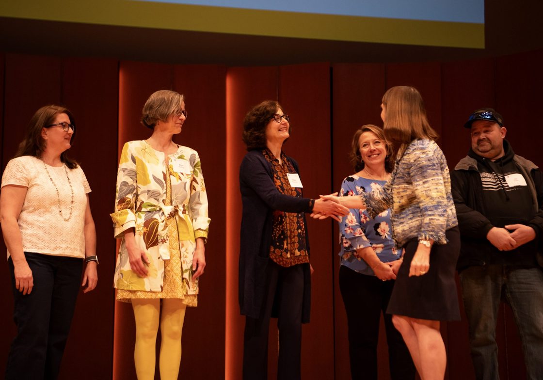 Carleton President Alison B. greeting staff Helena Kaufman.